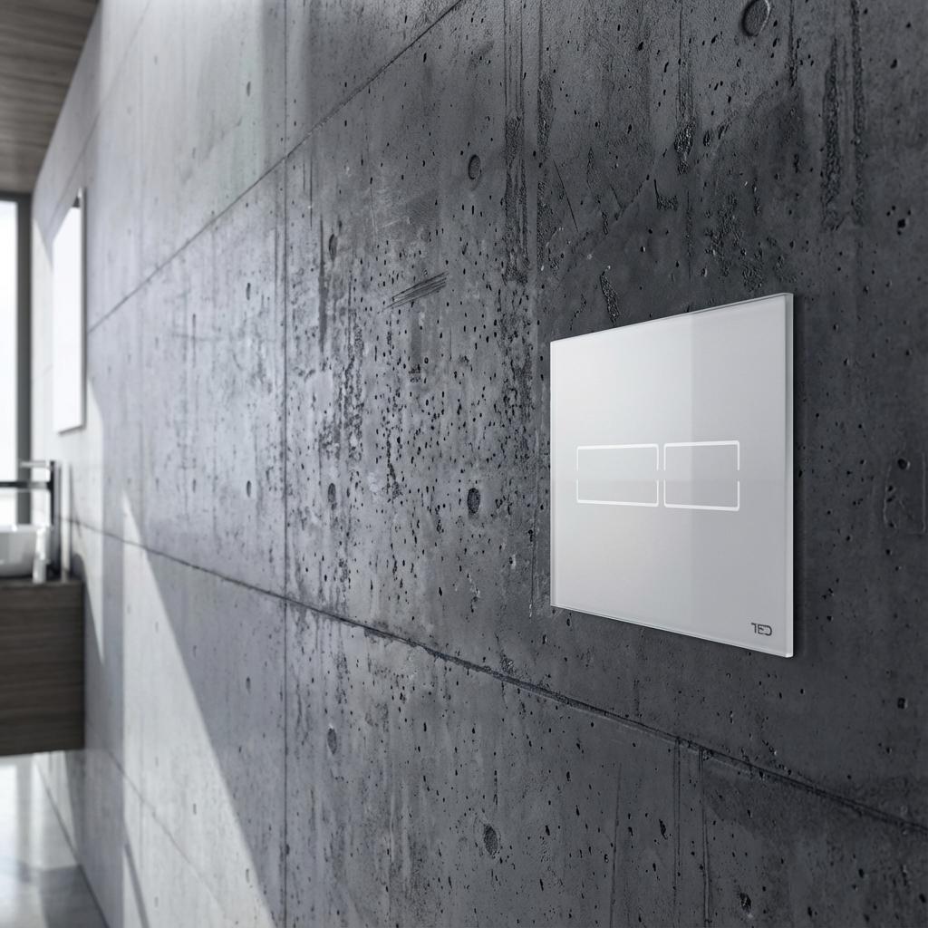 Eine weiße, rechteckige WC-Spülplatte mit zwei Tastenrahmen ist auf einer strukturierten dunkelgrauen Betonwand montiert. Links im Hintergrund sind ein weißes Waschbecken und ein Holzwaschtisch unter einem Fenster zu sehen.